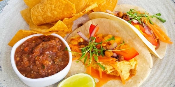 Tacos, tortilla chips and salsa on a plate at Level Blue