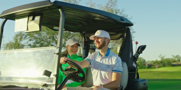 Golfers smiling while riding golf cart