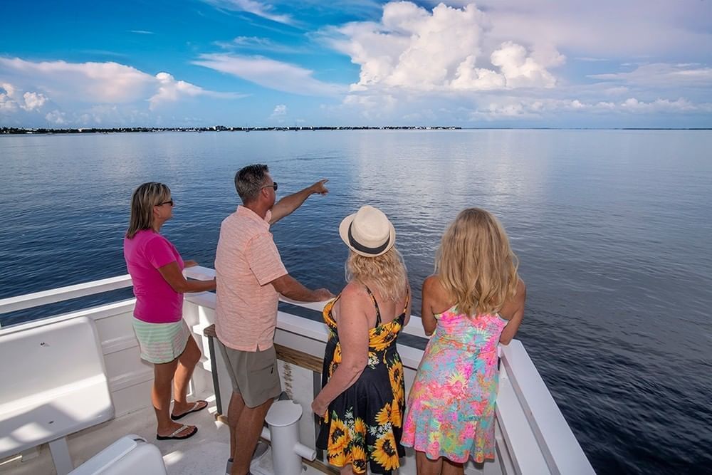 Family on a sightseeing cruise with man pointing at scenic views