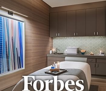 Forbes text over image of massage room