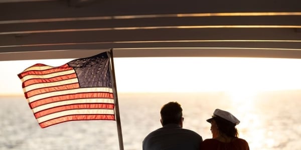 Couple on sunset cruise with American flag next to them
